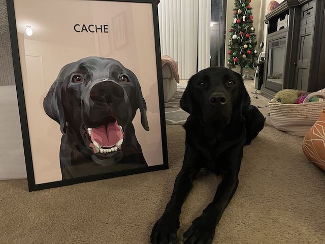 A dog sitting beside a portrait of itself smiling